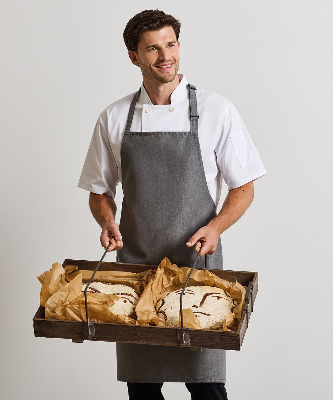Chef wearing Premier chef's jacket and bib apron - ColorCoded Workwear