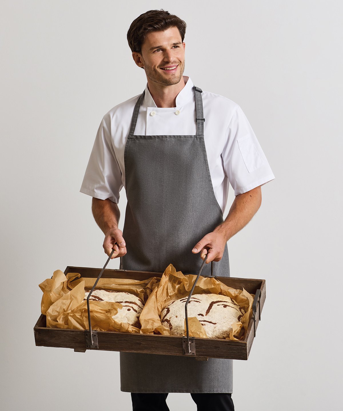 Chef wearing Premier chef's jacket and bib apron - ColorCoded Workwear