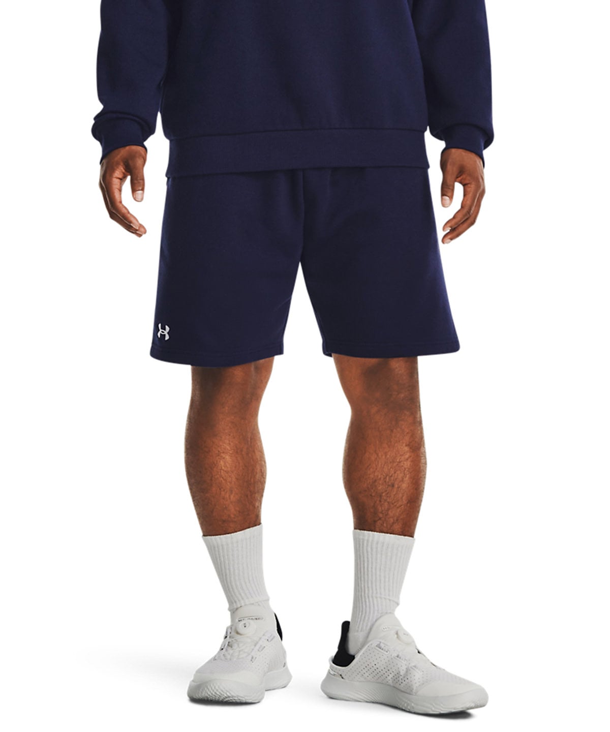 Person wearing navy blue shorts with a logo on a white background